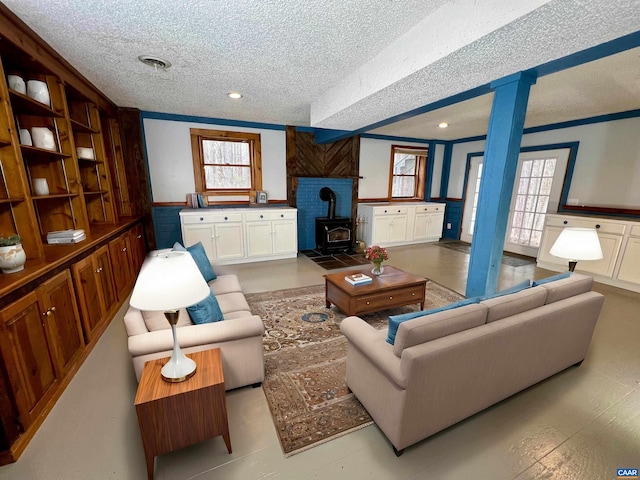 living room featuring a wainscoted wall, ornamental molding, and a wood stove