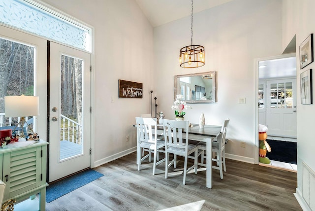 dining room featuring hardwood / wood-style flooring, high vaulted ceiling, french doors, and a chandelier