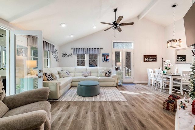 living room with high vaulted ceiling, ceiling fan, light hardwood / wood-style floors, beam ceiling, and french doors