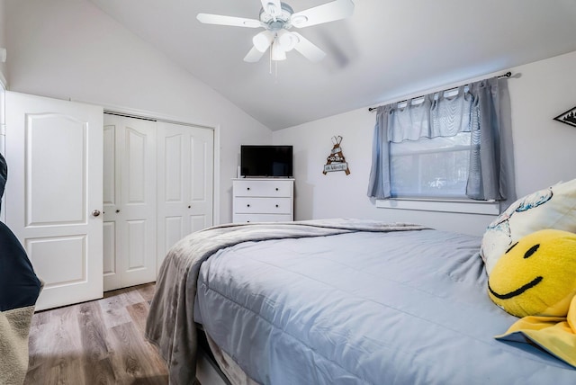 bedroom featuring ceiling fan, lofted ceiling, light wood-type flooring, and a closet