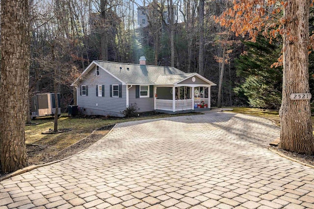 ranch-style home with central AC unit and covered porch