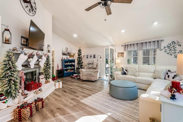 living room featuring ceiling fan, lofted ceiling, and light wood-type flooring