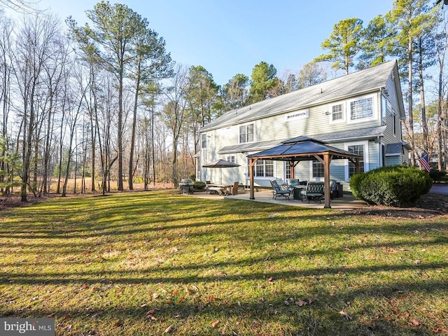 rear view of property featuring a gazebo, a yard, and a patio area