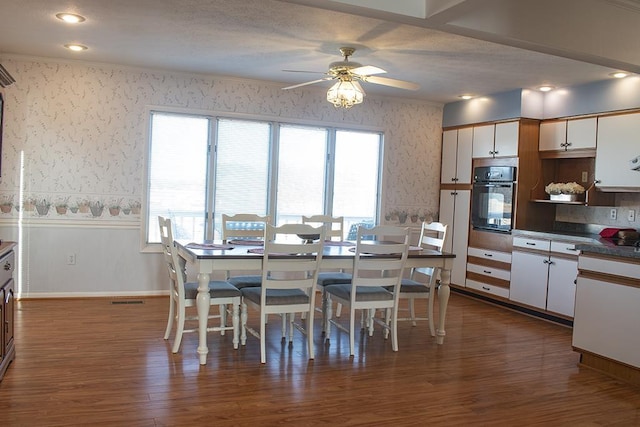 dining area featuring ceiling fan and dark hardwood / wood-style flooring