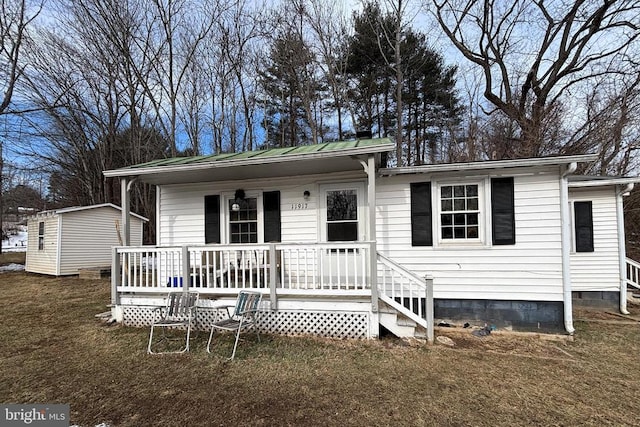 view of front facade featuring a storage shed and a front lawn