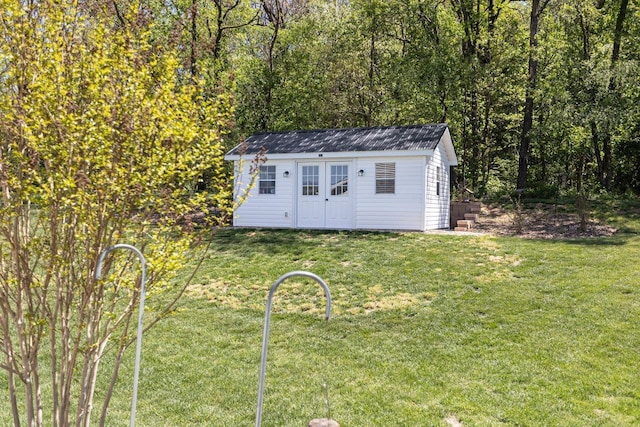 view of outdoor structure with a view of trees and an outbuilding