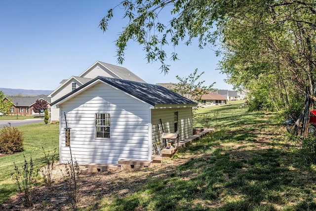 view of side of home featuring a yard and metal roof