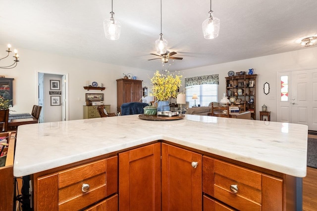 kitchen featuring light countertops, hanging light fixtures, ceiling fan, and open floor plan