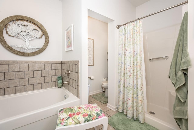 bathroom with tile patterned flooring, toilet, baseboards, a bath, and a shower stall
