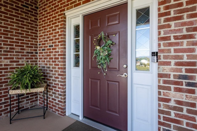 entrance to property with brick siding and a porch
