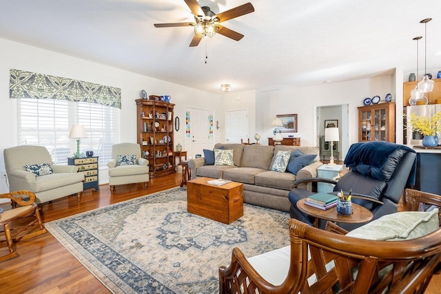 living area with a ceiling fan and wood finished floors