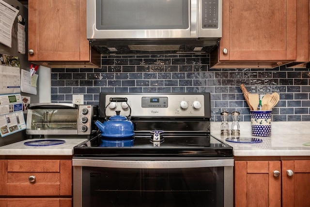 kitchen with light countertops, appliances with stainless steel finishes, and tasteful backsplash