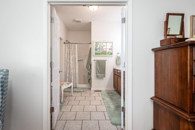 full bath with a shower stall, tile patterned flooring, and vanity