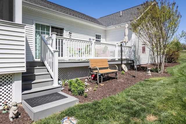 back of house featuring a shingled roof and a deck