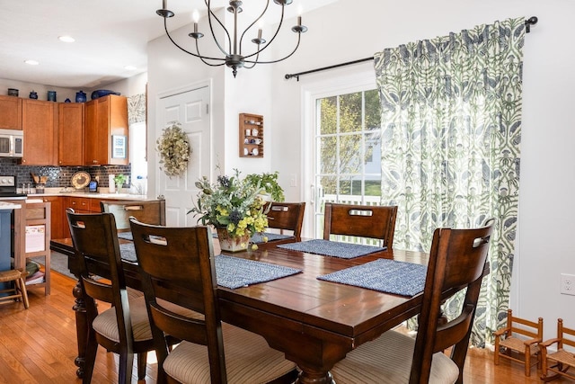 dining room with recessed lighting, light wood finished floors, and a chandelier