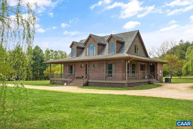 farmhouse featuring roof with shingles, cooling unit, a porch, and brick siding
