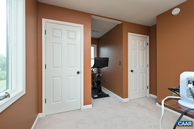 interior space featuring baseboards, visible vents, plenty of natural light, and carpet