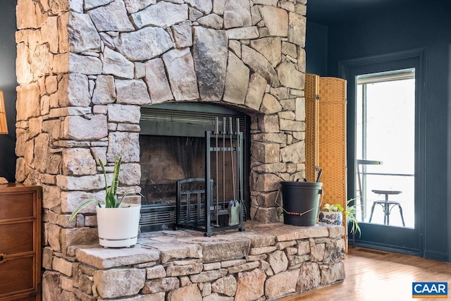 details featuring visible vents, wood finished floors, and a stone fireplace