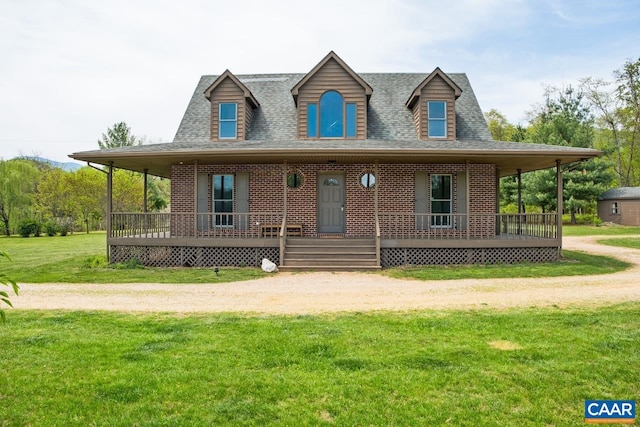 farmhouse with a porch, brick siding, roof with shingles, and a front lawn