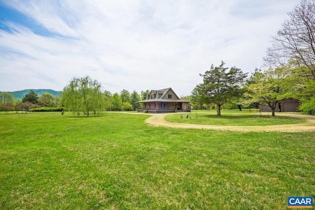 view of yard featuring an outdoor structure, a garage, and driveway