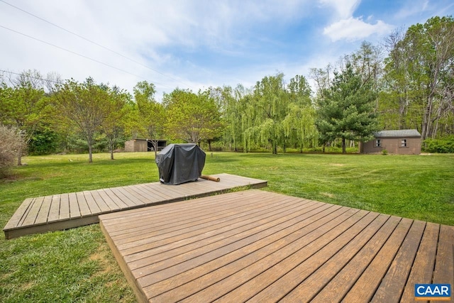 wooden terrace featuring a yard, an outbuilding, and area for grilling