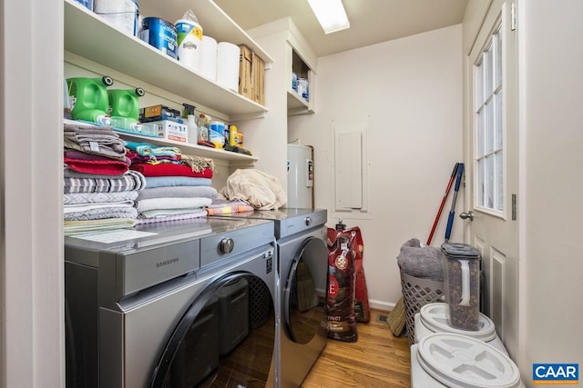 laundry room with washing machine and clothes dryer, laundry area, baseboards, wood finished floors, and electric water heater