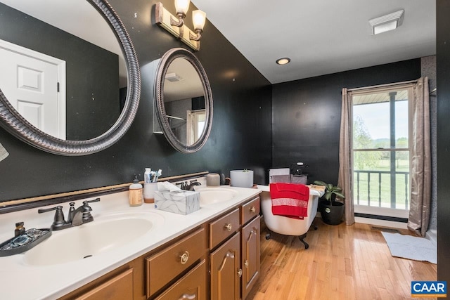 bathroom featuring a sink, double vanity, wood finished floors, and visible vents