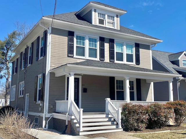 american foursquare style home featuring a porch and roof with shingles