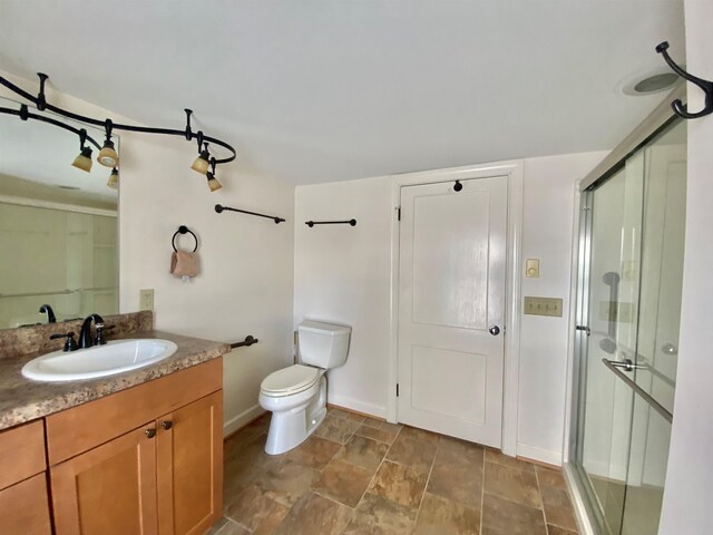 full bath with toilet, a shower stall, vanity, and baseboards