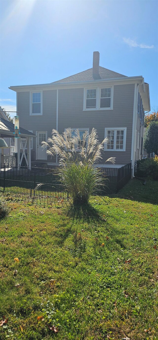 back of house featuring a lawn