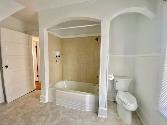 bathroom featuring tiled shower / bath combo and toilet