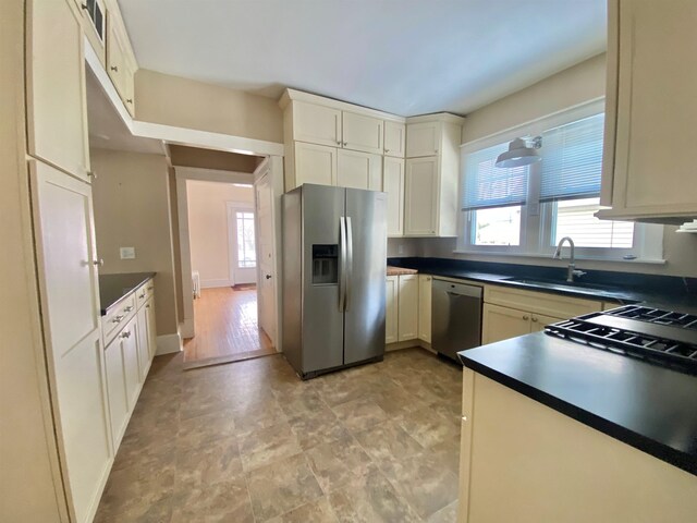 kitchen featuring sink, a wealth of natural light, cream cabinetry, and appliances with stainless steel finishes