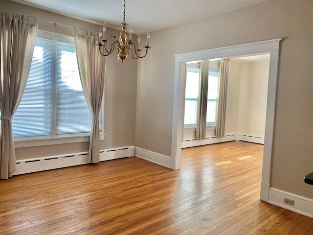 unfurnished dining area featuring an inviting chandelier, a healthy amount of sunlight, light hardwood / wood-style floors, and baseboard heating