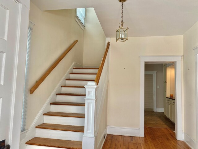 staircase with wood-type flooring and baseboards