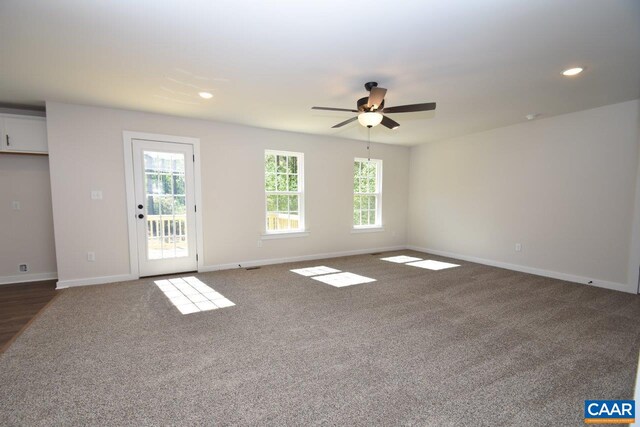 unfurnished room featuring ceiling fan and dark carpet