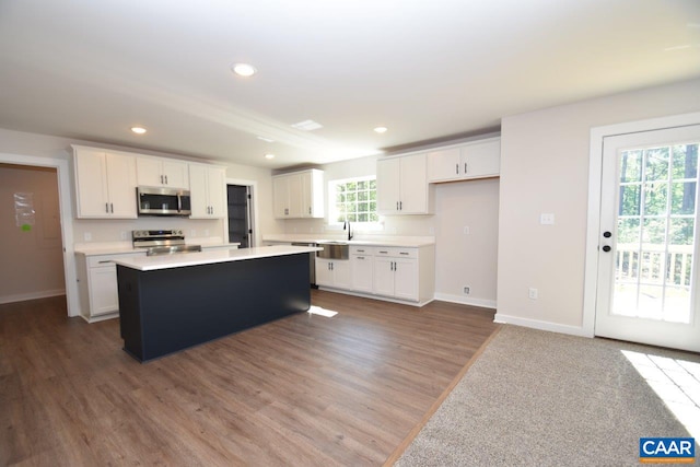 kitchen with a center island, recessed lighting, light countertops, appliances with stainless steel finishes, and white cabinetry