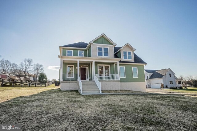 view of front of home with a garage, a front yard, and covered porch