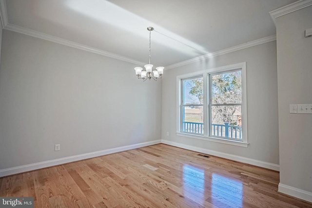 unfurnished room with a notable chandelier, ornamental molding, and light hardwood / wood-style floors