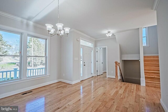 entryway featuring ornamental molding, a chandelier, and light hardwood / wood-style flooring