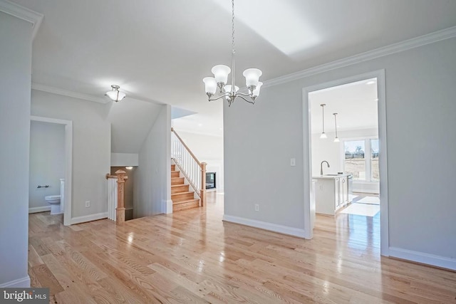 unfurnished dining area with crown molding, a notable chandelier, sink, and light wood-type flooring