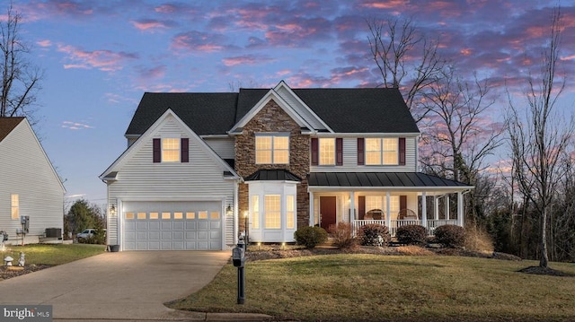 view of front facade featuring a garage, a lawn, central AC, and a porch