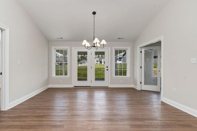 unfurnished dining area with an inviting chandelier, visible vents, a healthy amount of sunlight, and dark wood finished floors