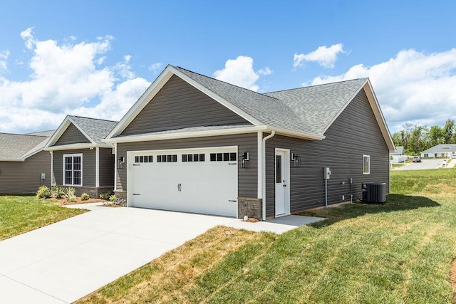 view of side of home with concrete driveway, a lawn, roof with shingles, and a garage
