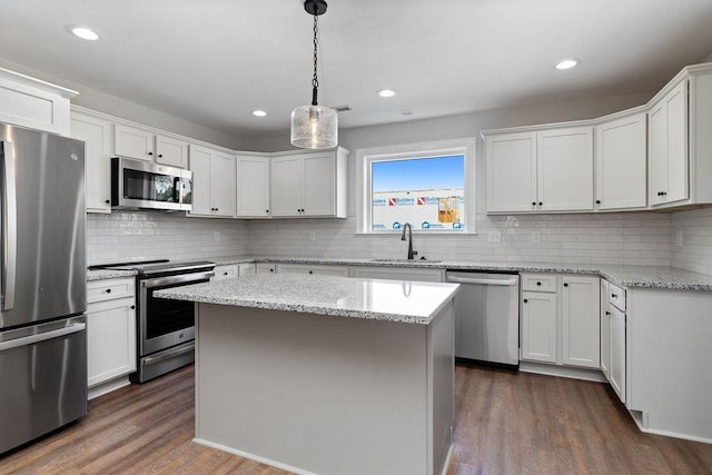 kitchen featuring dark wood-style flooring, decorative backsplash, appliances with stainless steel finishes, and a sink