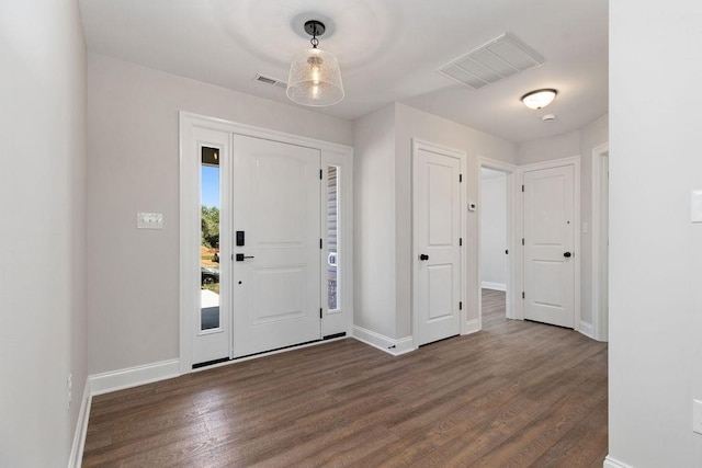 foyer featuring visible vents, baseboards, and dark wood-style floors
