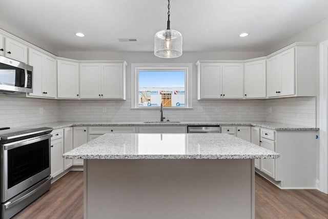 kitchen featuring dark wood finished floors, appliances with stainless steel finishes, white cabinets, and a sink