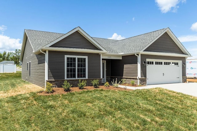 view of front facade with roof with shingles, an attached garage, stone siding, concrete driveway, and a front lawn