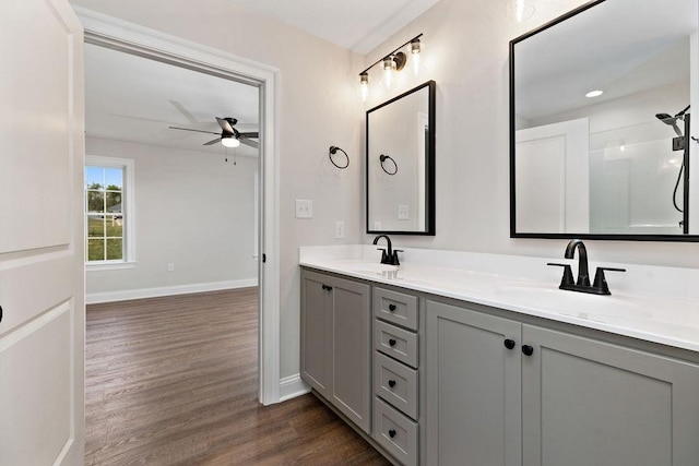 full bathroom featuring a sink, double vanity, a ceiling fan, and wood finished floors
