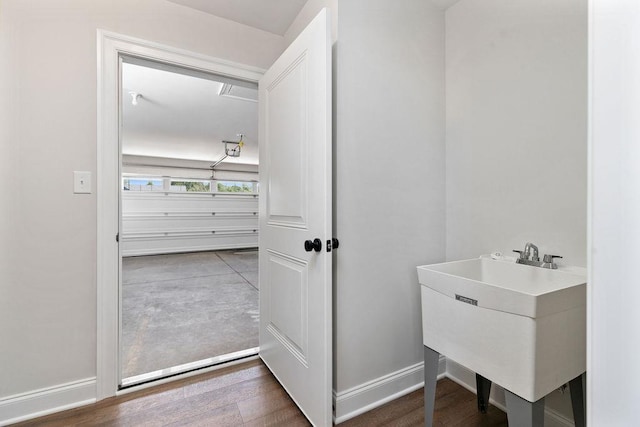 bathroom with wood finished floors, baseboards, and a sink