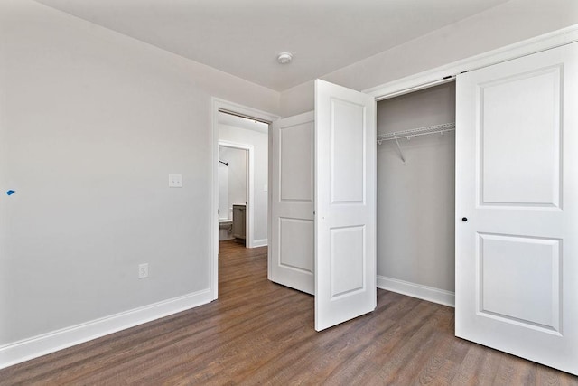 unfurnished bedroom featuring a closet, wood finished floors, and baseboards